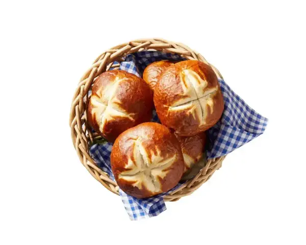 Koszyk z kilkoma bułkami bawarskimi, ułożonymi na niebiesko-białej kratkowanej serwetce.