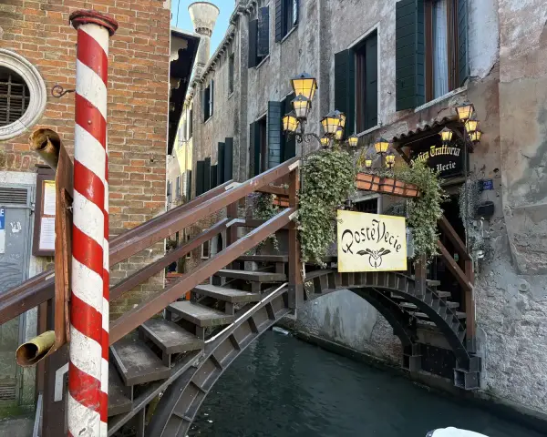 Ponte in legno a Venezia, con insegna "Roste Vecie". Perfetto per un free tour alla scoperta dei vicoli nascosti.