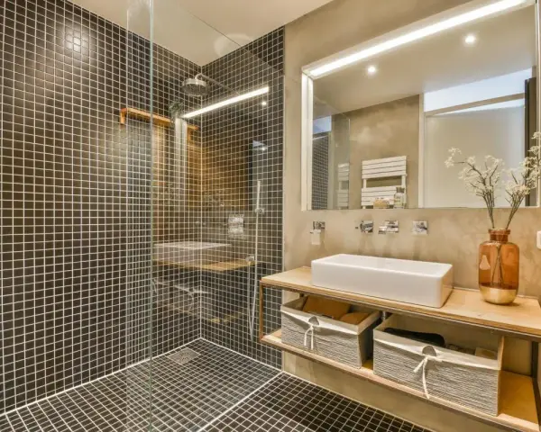 A modern bathroom with a walk-in tiled shower. Learn how to clean a walk-in tiled shower with this stylish setup.