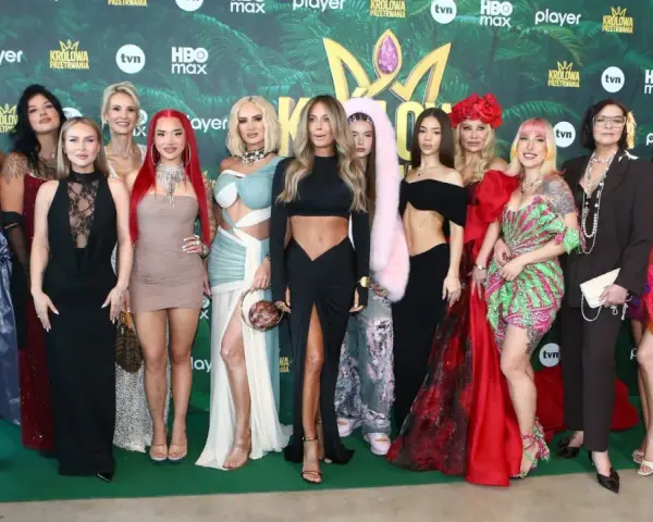 Królowe przetrwania 3 na premierze. Grupa kobiet w barwnych kreacjach pozuje na zielonym tle z logotypami wydarzenia.