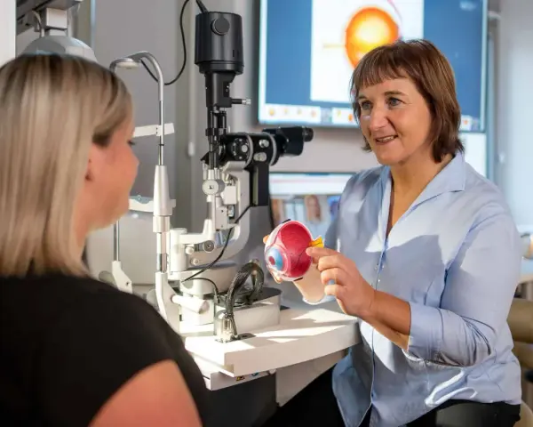 Augenarzt erklärt Modellauge. Mögliche Behandlung: Augen lasern. Krankschreibung wird besprochen.