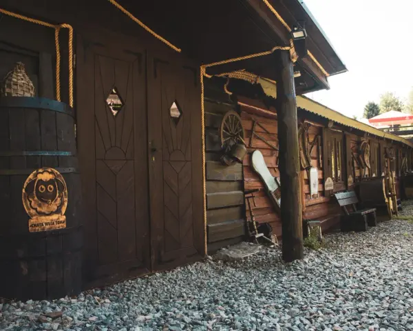 Drewniana chata wuja Toma z beczką i ozdobami.