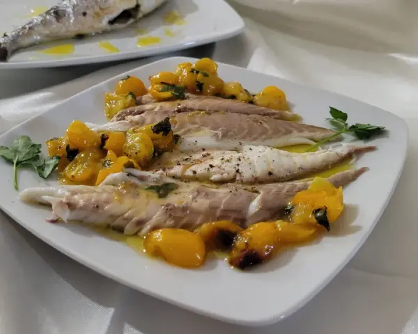 Orata in friggitrice ad aria, servita con pomodorini gialli e prezzemolo. Un piatto leggero e gustoso.