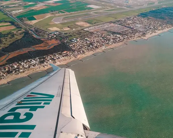 Widok z samolotu Alitalia na wybrzeże Włoch. Zastanawiasz się, ile się leci do Włoch? Już niedługo poczujesz słońce!