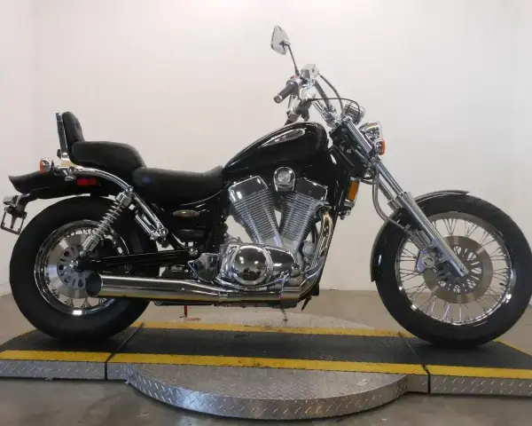 Czarny motocykl Suzuki Intruder 1400 z chromowanymi elementami, siedzeniem pasażera i bagażnikiem.