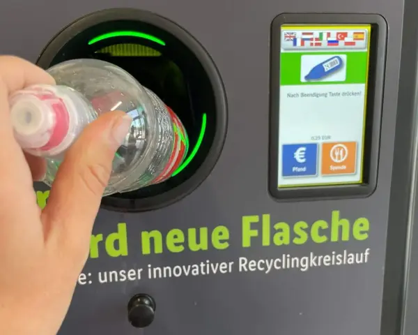 Ręka wrzuca butelkę do automatu. Niemiecki system kaucyjny działa sprawnie, zwracając 0,25 EUR za każdy zwrot.