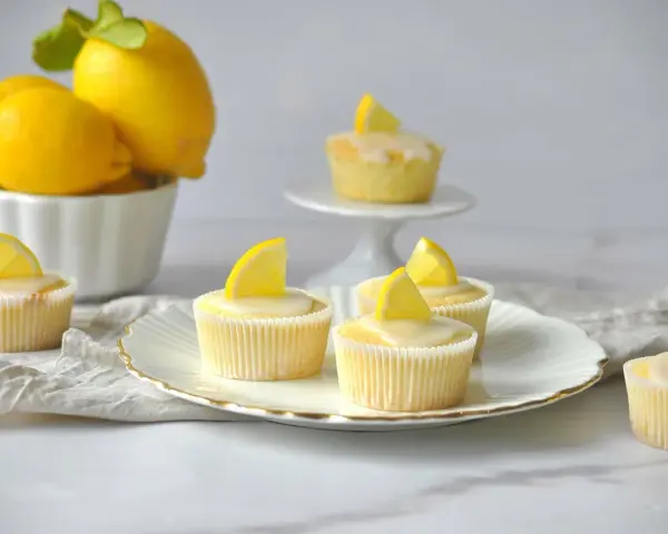 Erfrischende Zitronenmuffins mit Zuckerguss und Zitronenspalten, inspiriert von einem einfachen zitronenmuffins rezept.