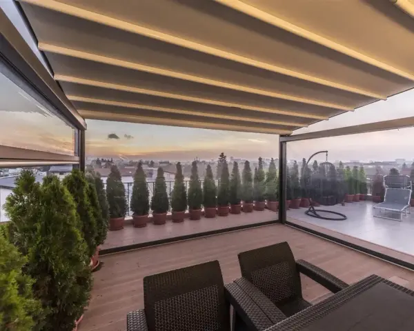 Terrazzo trasformato in stanza con chiusura trasparente, ideale per godersi il panorama.