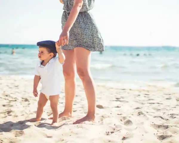 Mama i dziecko na plaży, idealne miejsce, by zapytać, gdzie lecieć w kwietniu. Słońce, piasek i morze.