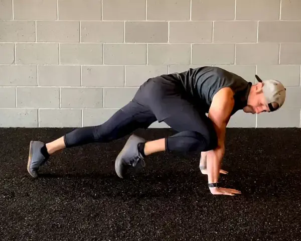 Un homme fait des mountain climbers pour son renforcement musculaire à la maison.