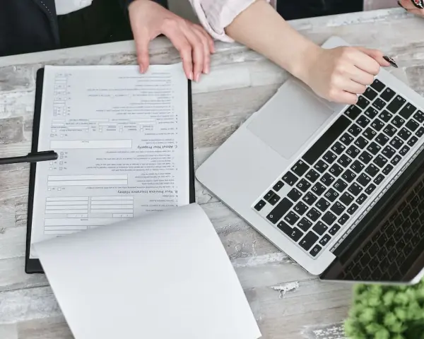 Dwie osoby przy biurku analizują dokumenty i laptopa. Planują swoją **pracę w Holandii**.