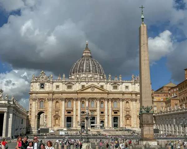 St. Peter's Basilica, one of the most beautiful churches in Rome, stands majestically with its dome and an ancient obelisk in the foreground.