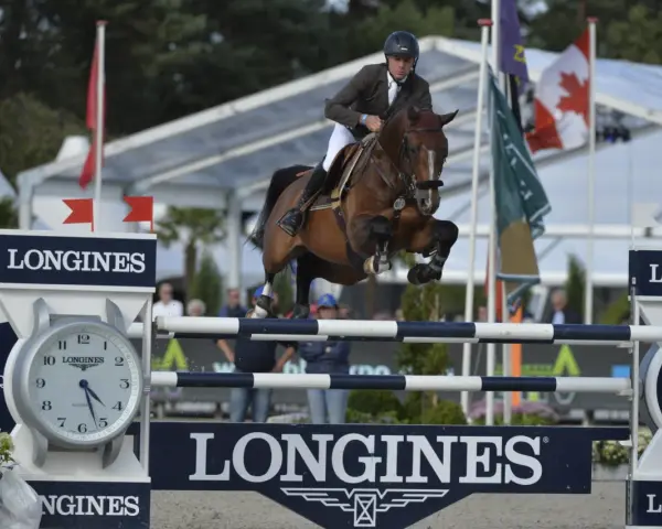 Le cavalier Cooper van de Heffinck et son cheval sautent un obstacle lors d'une compétition équestre.