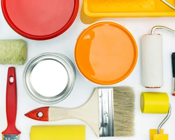 Pennelli, rulli e barattoli di vernice colorata, pronti per dipingere e come evitare i segni del rullo in controluce.