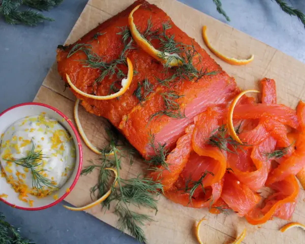 Rökt lax med apelsinzest och dill, serverad med en krämig sås till lax. Perfekt för en festlig måltid.