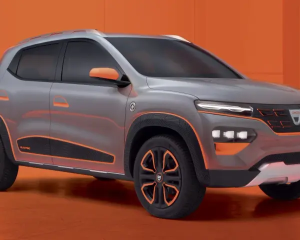 Szary samochód Dacia Spring z pomarańczowymi akcentami na tle pomarańczowym.