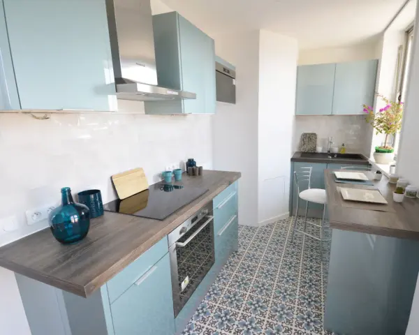 Cocina moderna y luminosa con armarios celestes y suelo hidráulico. Una opción económica para renovar cocina con poco dinero.