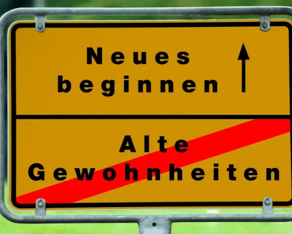 Gelbes Ortsschild: Oben "Neues beginnen" mit Pfeil nach oben, unten "Alte Gewohnheiten" durch roten Balken durchgestrichen. Das Symbol steht für die **passion bedeutung** neuer Wege.
