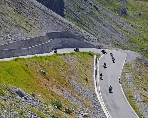Motocykliści przemierzają kręte trasy w górach, ciesząc się wolnością i pięknymi widokami. To idealne miejsce na odkrywanie polskich tras motocyklowych.