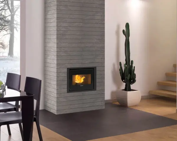 Camino a pellet con fiamme vive, un cactus e un tavolo da pranzo. Il pellet migliore qualità per un ambiente caldo.