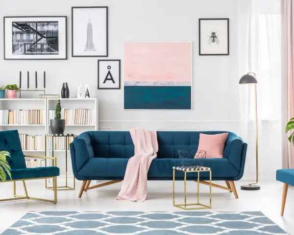 Granatowa sofa i fotele z pudrowym różem tworzą elegancką przestrzeń.