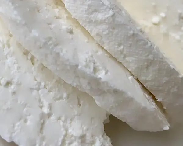 Świeży, biały twaróg z mleka krowiego, pokrojony w kawałki. Idealny do sernika lub na kanapki.