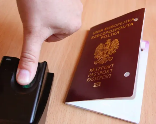 Palec na czytniku linii papilarnych obok polskiego paszportu. To pokazuje, ile ważny jest paszport w dzisiejszych czasach.