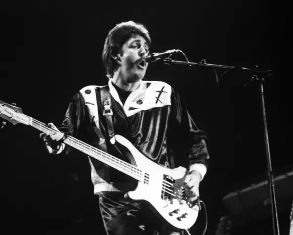 Paul McCartney, jeden z legendarnych amerykańscy piosenkarze lat 80., gra na gitarze basowej podczas koncertu.