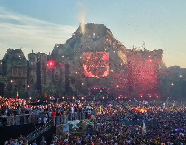 Tłum ludzi na największym festiwalu muzycznym na świecie, z wulkaniczną sceną i pokazem sztucznych ogni.