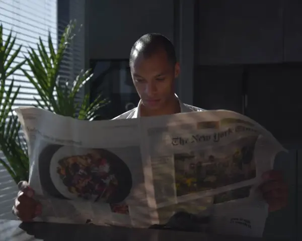 Mężczyzna czyta "The New York Times", zastanawiając się, czy urlop przechodzi do nowego pracodawcy.