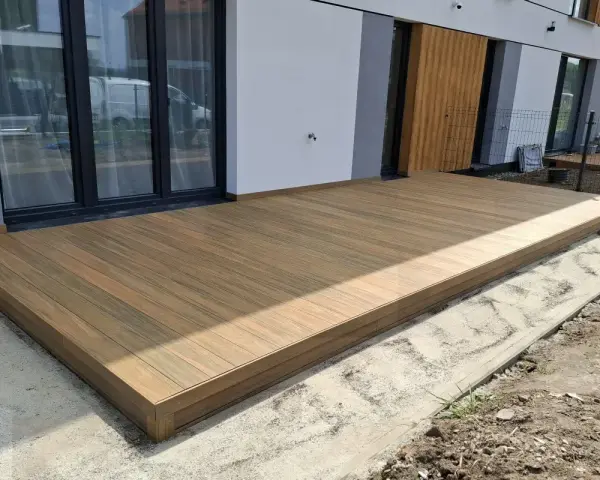 Nowy taras na słupach betonowych, wykonany z desek kompozytowych, stanowi idealne miejsce do wypoczynku.