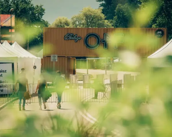 Ludzie idą po bilety na OFF festival. W tle widać logotyp festiwalu.