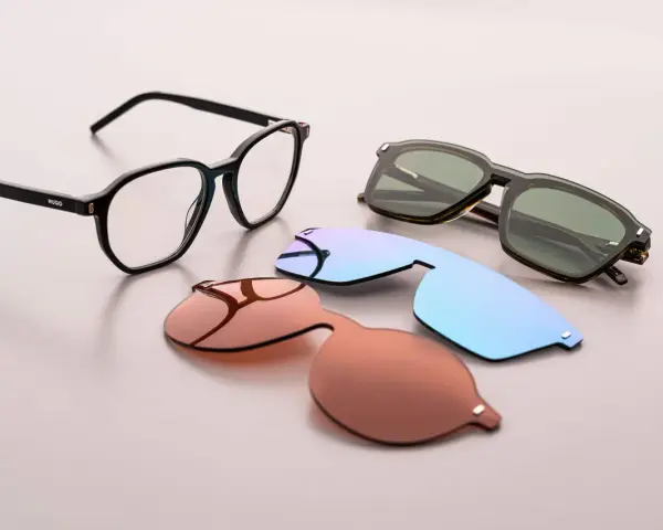 Occhiali da vista Hugo Boss AG con lenti intercambiabili: una montatura nera, lenti da sole marroni, azzurre e verdi.