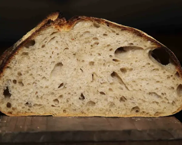 Schnitt eines rustikalen Pain au Levain mit luftiger Krume und knuspriger Kruste.