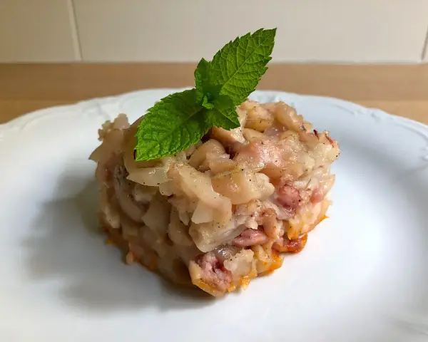 Deliciosa terrina de manitas de cerdo, con trozos tiernos y gelatinosos, coronada con una hoja de menta fresca.