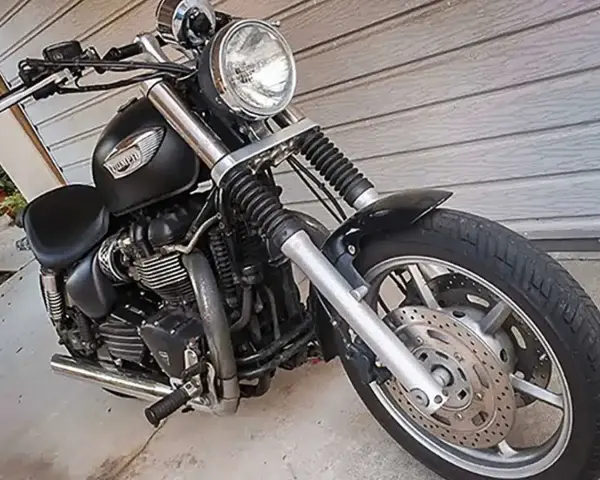 Czarny motocykl Triumph Speedmaster z chromowanymi elementami, gotowy na przygodę.