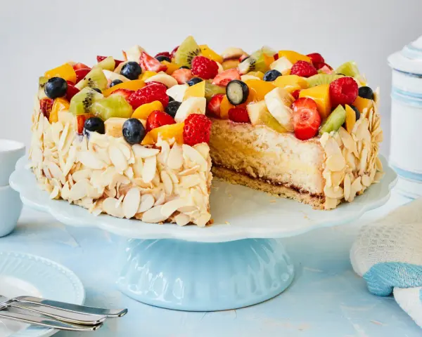 Ein bunter Obstkuchen, verziert mit Mandelsplittern, inspiriert zu neuen obstkuchen rezepten.