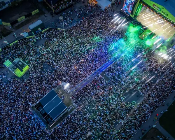 Tłum ludzi na koncercie podczas Łódź Summer Festival 2026. Kolorowe światła i dym tworzą niesamowitą atmosferę.