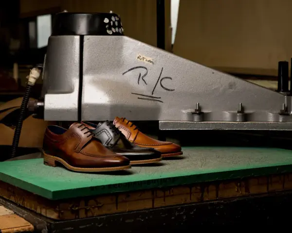 Scarpe eleganti in pelle marrone e nera, pronte per essere lavorate per ammorbidire la pelle.