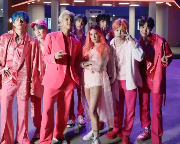 BTS und Halsey in pinken Outfits, ein Bild, das die vielen BTS Spotify Streams feiert.