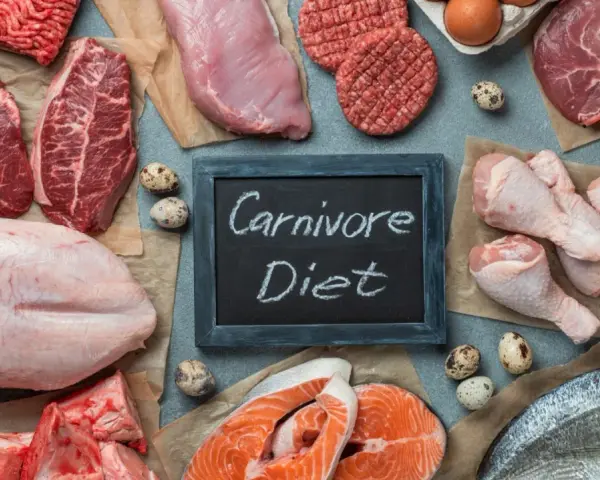 Różnorodne mięsa, ryby i jaja na stole. Tabliczka z napisem "Carnivore Diet" sugeruje potencjalne dieta karniwora efekty.