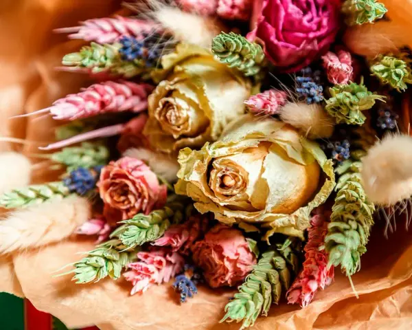En vacker bukett med torkade blommor, som rosor och lavendel, visar hur torkar man blommor för att bevara deras skönhet.