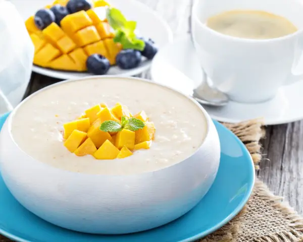 Pyszny deser z mango, jagodami i kawą. Ten mango smak to idealny początek dnia.