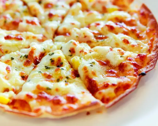 Pyszna, gorąca pizza z patelni, z ciągnącym się serem i ziołami, gotowa do podania.