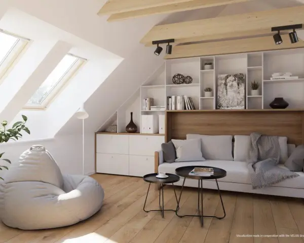 Accogliente salotto in mansarda con divano, pouf, libreria e lucernari che inondano lo spazio di luce.