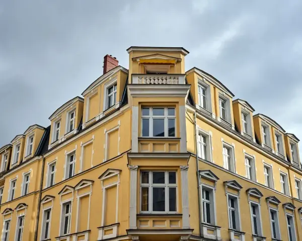 Żółta kamienica z zabytkowymi detalami, gdzie właśnie trwa wymiana okien w budynku wpisanym do gminnej ewidencji zabytków.