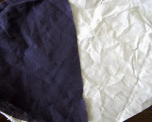 Dwa kawałki materiału, jeden granatowy, drugi biały, przypominają, że **cotton co to** za materiał – miękki i naturalny.