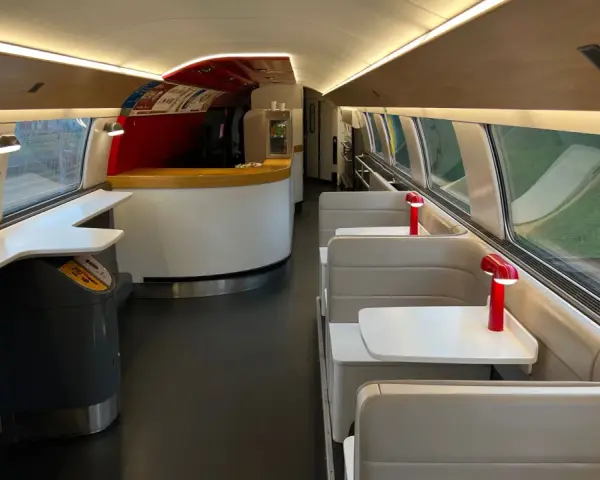 Interior of a TGV train carriage, ready for a journey from Amsterdam to Bordeaux. Booth seating and a bar area await passengers.