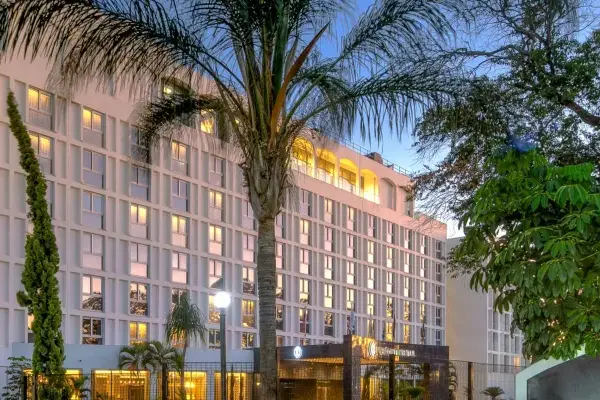 Elegancki hotel w Lusace, stolicy Zambii, otoczony bujną zielenią i palmami.