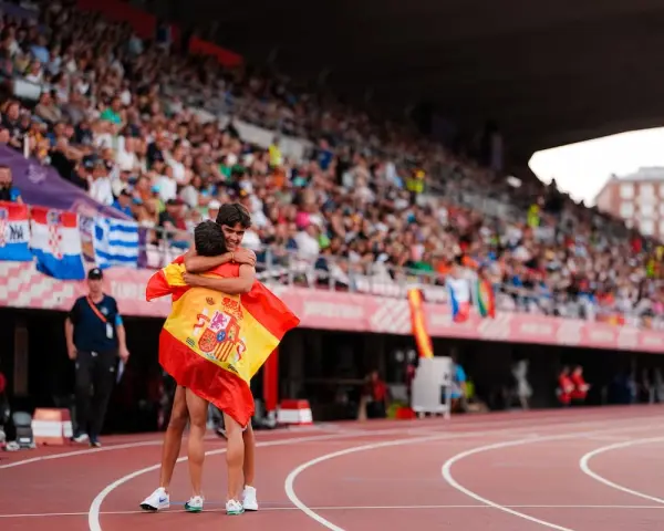 Dos atletas se abrazan con la bandera de España en el campeonato Europa sub 20 atletismo.